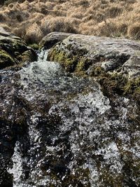 High angle view of stream flowing through rocks