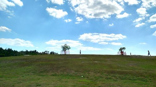 Scenic view of grassy field against sky