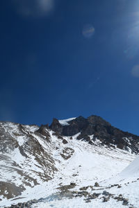 Scenic view of snowcapped mountains against blue sky