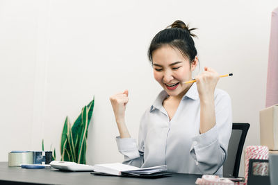 Young woman using phone while sitting on table