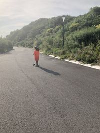 Rear view of man walking on road