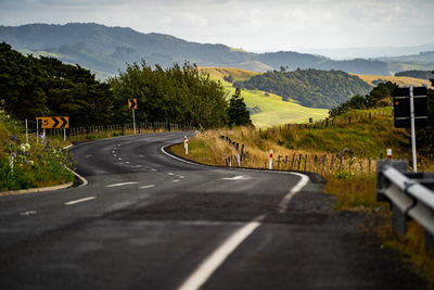 Empty road by mountain against sky