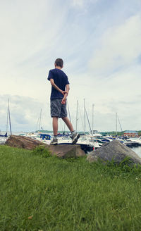 Man standing on shore by sea against sky