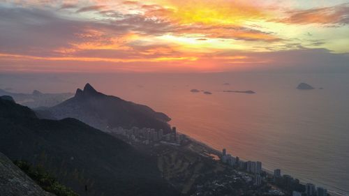 Scenic view of sea against cloudy sky during sunset