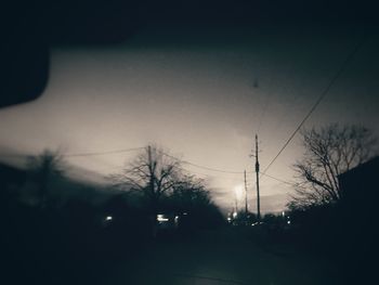 Silhouette of trees and buildings against sky