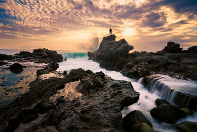 Silhouette man standing on rock at lombok island during sunset