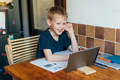 Boy sitting on table at home