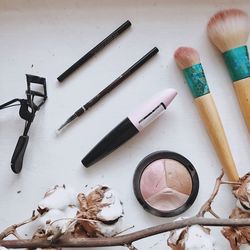 High angle view of beauty products by dried cotton plant on table