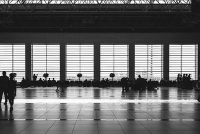 Silhouette people at airport against sky