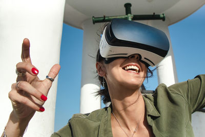 Laughing woman wearing virtual reality simulator outdoors