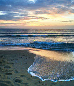 Scenic view of beach against sky during sunset