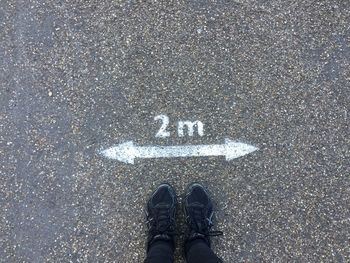Low section of person standing on road