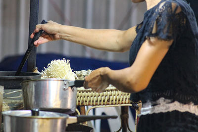 Midsection of woman cooking food in kitchen