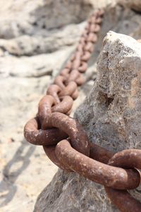 Close-up of rusty chain on rock