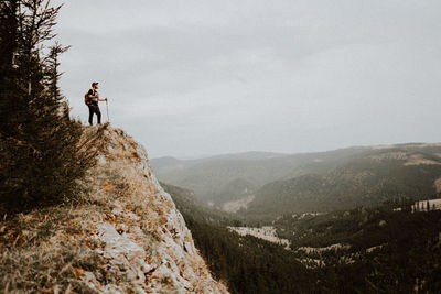 Man standing on mountain against sky