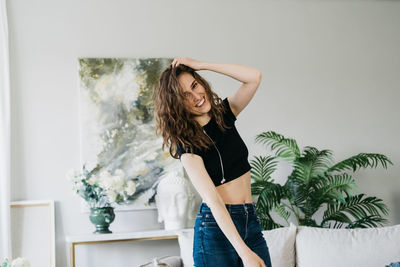 Beautiful young woman dancing at home alone in headphones.