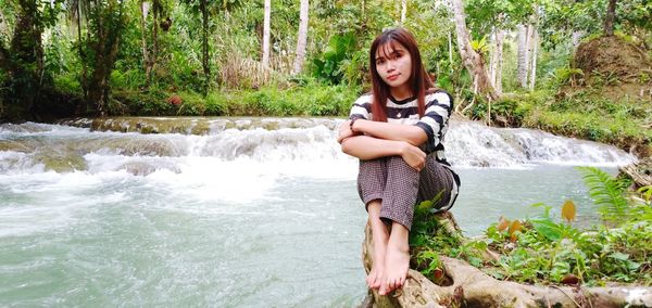 Portrait of young woman standing in lake