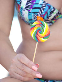 Midsection of woman holding multi colored candies