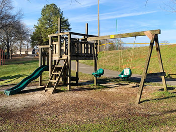 Empty swing in park against sky