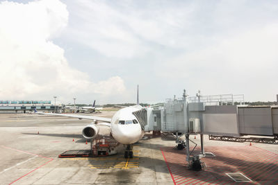 Airplane on airport runway against sky