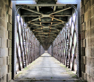 Empty bridge amidst buildings