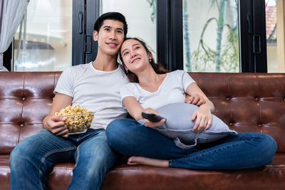 Young couple watching tv at home