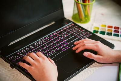 Cropped hands using laptop on table