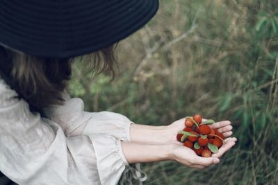 Midsection of woman holding fruit on field