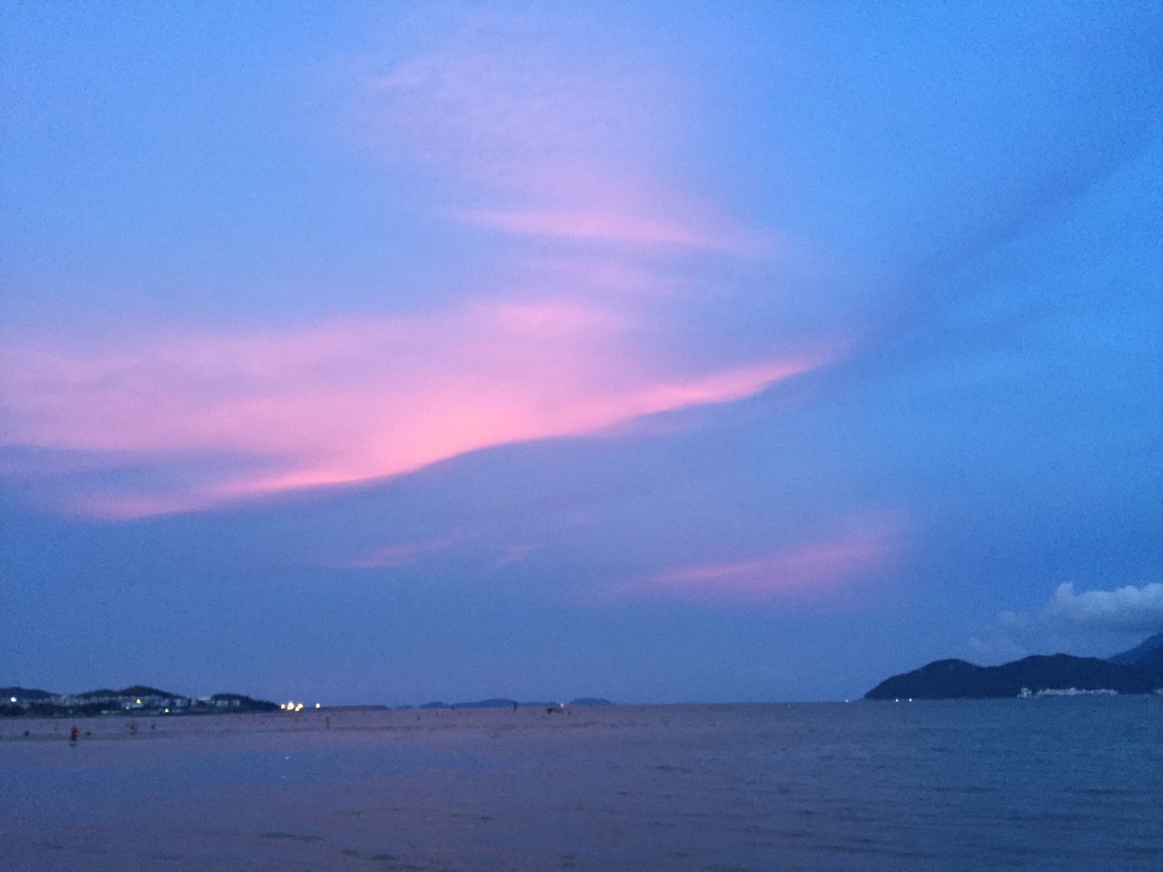 water, tranquil scene, waterfront, scenics, tranquility, sky, cloud, beauty in nature, sea, calm, nature, blue, ocean, seascape, cloud - sky, outdoors, moody sky, water surface, dramatic sky, no people, distant, pink color, coastline