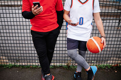 Cropped portrait of male friends checking their phone after a game at a basketball court. copy space.