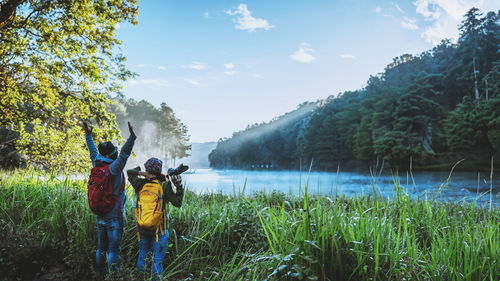 Rear view of woman standing by lake