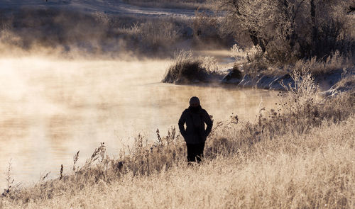 Woman standing on grass by river