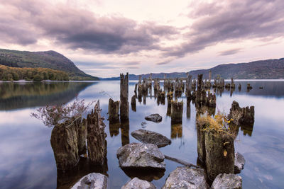 Panoramic view of rocks in lake against sky during sunset