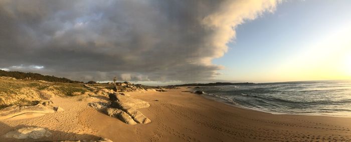 Scenic view of beach against sky during sunset