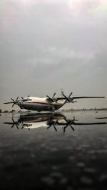 Airplane flying over airport against sky