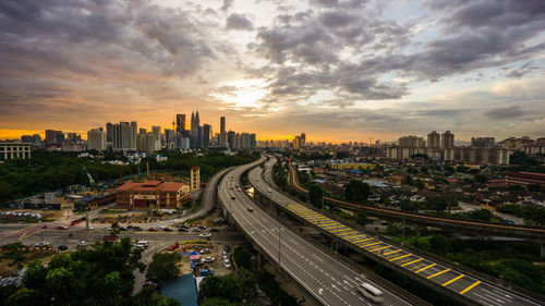 High angle view of street amidst buildings against sky during sunset