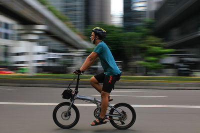Full length side view of man riding bicycle