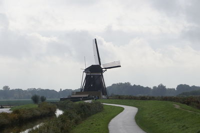 Traditional windmill on field against sky