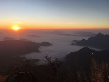 Scenic view of silhouette mountains against orange sky