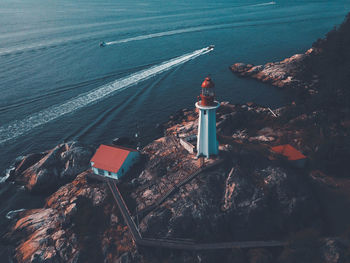 High angle view of lighthouse by sea and buildings