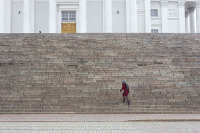 Full length of woman walking against building