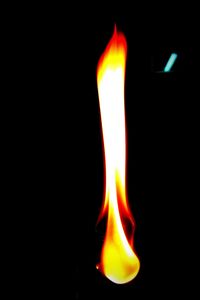 Close-up of lit candle in dark room