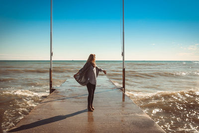 Woman standing on beach against clear sky