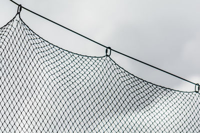 Low angle view of chainlink fence against sky