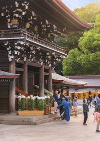 People walking outside temple against building