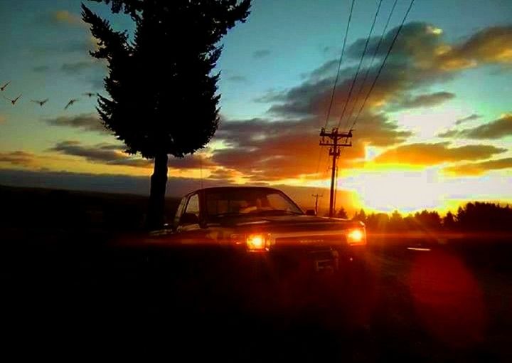 CARS ON ROAD AGAINST DRAMATIC SKY