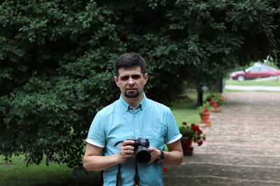 Full length of man photographing against trees