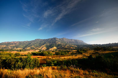 Scenic view of mountains against blue sky