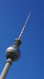 Low angle view of communications tower against clear blue sky