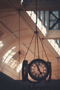 Close-up of clock hanging on ceiling